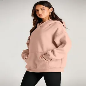 Detail shot of women's oversized dusty pink hoodie showing side pocket and casual fit