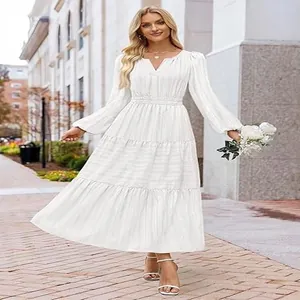 Elegant white V-neck tiered maxi dress with puff sleeves and cinched waist worn by model.
