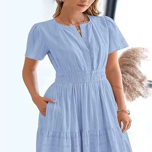 Detail of light blue V-neck tiered dress with puff sleeves and textured fabric.