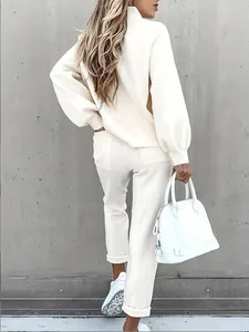 Vue arrière d'un ensemble chic sweat à manches longues crème et pantalon décontracté assorti.