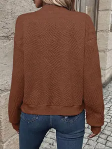 Vista macro dettagliata del motivo geometrico su una giacca marrone da donna alla moda.