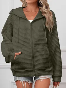 Detail view of a casual olive green waffle textured zip-up hooded jacket for women.