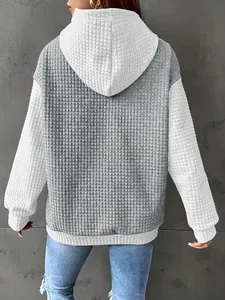 Back view detail of a stylish oversized color-block waffle knit hooded sweatshirt for women