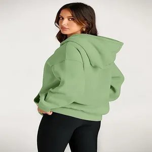 Detailed back view of a casual oversized light green hooded sweatshirt for women.