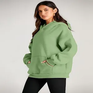 Professional studio shot of a women's sage green oversized hooded sweatshirt with pocket