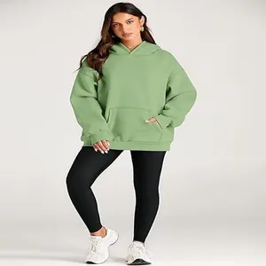 Stylish women's oversized sage green hooded sweatshirt paired with sleek black leggings