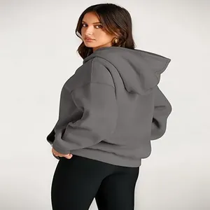 Back view of a woman wearing an oversized charcoal grey hooded sweatshirt for winter