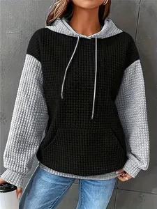 Detail view of a women's color-blocked waffle knit pullover hoodie with grey sleeves.