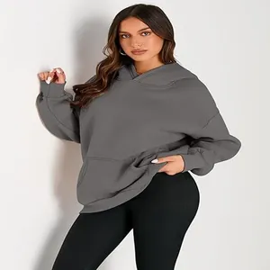 Detail view of a loose grey hooded sweatshirt featuring a front pocket and soft fabric.