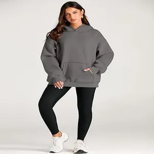 Close-up detail of women's oversized grey hoodie featuring pocket and drop shoulder design