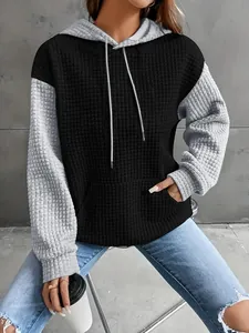 Detail view of women's color-blocked waffle knit hoodie with black body and grey sleeves