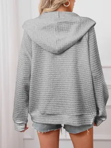 Back view of a grey waffle knit oversized hoodie showing textured fabric detail clearly