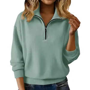 Detail eines salbeigrünen Strickpullovers mit Reißverschluss und Rippbündchen