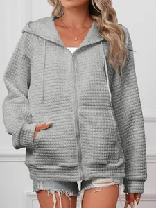 Detail view of a grey waffle knit hooded zip-up jacket with functional front pockets.