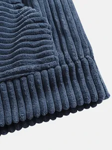Detailed close-up showing the blue corduroy fabric texture and ribbed hem of a men's hoodie