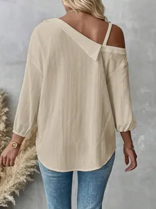 Detailed back view of a beige textured off-shoulder blouse with 3/4 sleeves and lapel.