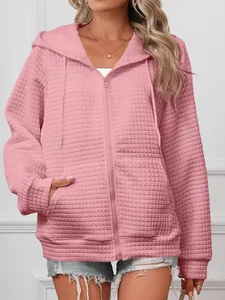 Close-up detail of a pink waffle knit zip-up hoodie with adjustable drawstrings.