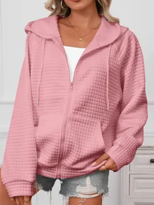 Close-up detail of a pink waffle-knit hooded zip-up sweatshirt for women's casual wear
