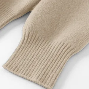 Nahaufnahme des gerippten Bündchens eines beigen Strickpullovers für den Winter