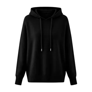 Detailed view of black knitted hooded sweater with drawstring and ribbed texture