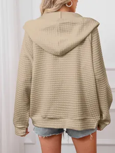 Detailed back view of a women's beige waffle-textured hooded sweatshirt jacket