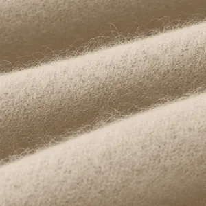 Makroansicht der weichen beigen Strickstofftextur mit feinen Fasern und Falten