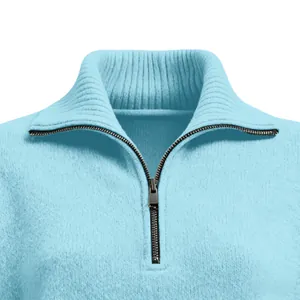 Nahaufnahme von Stehkragen und silbernem Reißverschluss an einem hellblauen Strickpullover