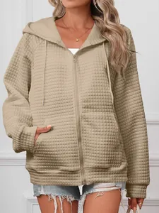 Close-up detail of a khaki waffle-textured zip-up hooded jacket with drawstring cords