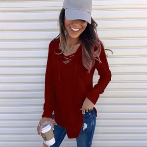 Close-up detail of dark red V-neck long sleeve top featuring stylish lace-up front design.