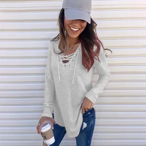 Close-up view of a woman wearing a stylish grey lace-up V-neck long-sleeve T-shirt top