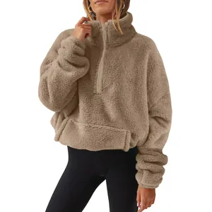 Close-up detail of women's oversized brown fuzzy fleece quarter-zip stand collar sweatshirt