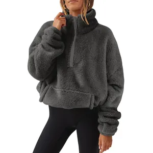 Detail view of a grey fluffy women's half-zip fleece sweatshirt with cozy sherpa texture.