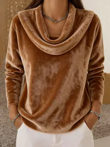 Dettaglio di un morbido top in velluto marrone con un elegante design a collo sciallato.