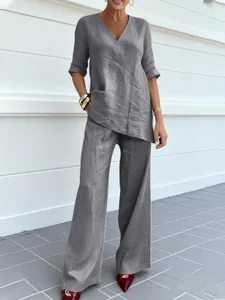 Vista completa de una mujer con un conjunto gris de algodón y lino con cuello en V y pantalón