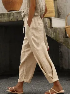 Detailed side view of women's beige linen trousers with elastic waist and side pockets