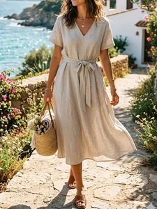 Photo d'un mannequin en robe en lin beige sur une côte méditerranéenne ensoleillée