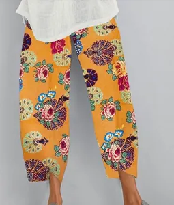 Détail de pantalon jaune pour femme avec imprimé floral et ourlet irrégulier