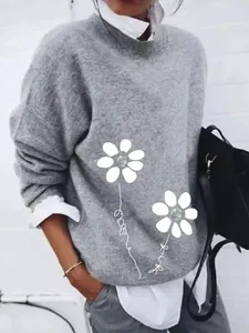 Detailed view of white floral prints on a grey brushed loose long-sleeved sweater