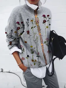 Vista dettagliata di un cardigan grigio da donna con stampa floreale e camicia.