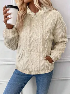 Close-up detail of cozy beige plush hooded sweatshirt featuring a textured jacquard cable pattern