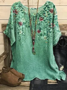 Detail view of a loose green floral print round neck top with linen-like texture