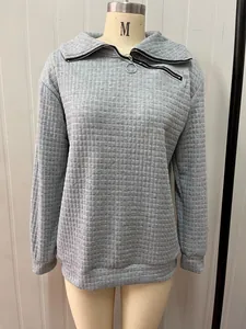 Nahaufnahme des grauen Stepp-Sweatshirts mit dem einzigartigen schrägen Halsreißverschluss