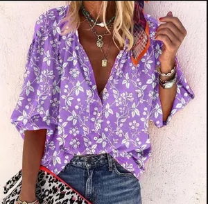 Gros plan d'une chemise à imprimé floral violet avec motifs blancs et boutons.
