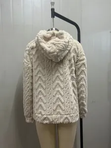 Close-up detail of cream textured fleece hoodie showcasing intricate jacquard patterns.