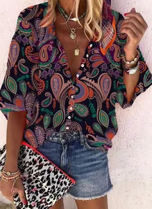 Dettaglio camicetta vintage da donna con stampa paisley, gioielli boho e shorts in denim.