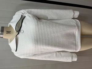 Detailansicht der weißen Steppstruktur und des schrägen Reißverschlusses eines Sweatshirts.