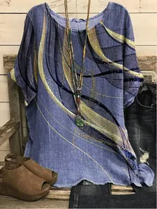 Macro view of blue loose tunic featuring abstract gold and black swirl print details