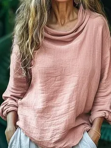 Close-up showing the textured crinkle fabric and cowl neck design of this pink top.