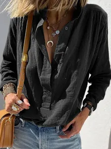 Detail view of a black cotton linen shirt featuring a textured fabric and button-up collar.
