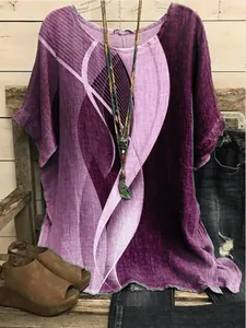 Close-up of women's loose purple tunic with abstract wave print on a rustic background